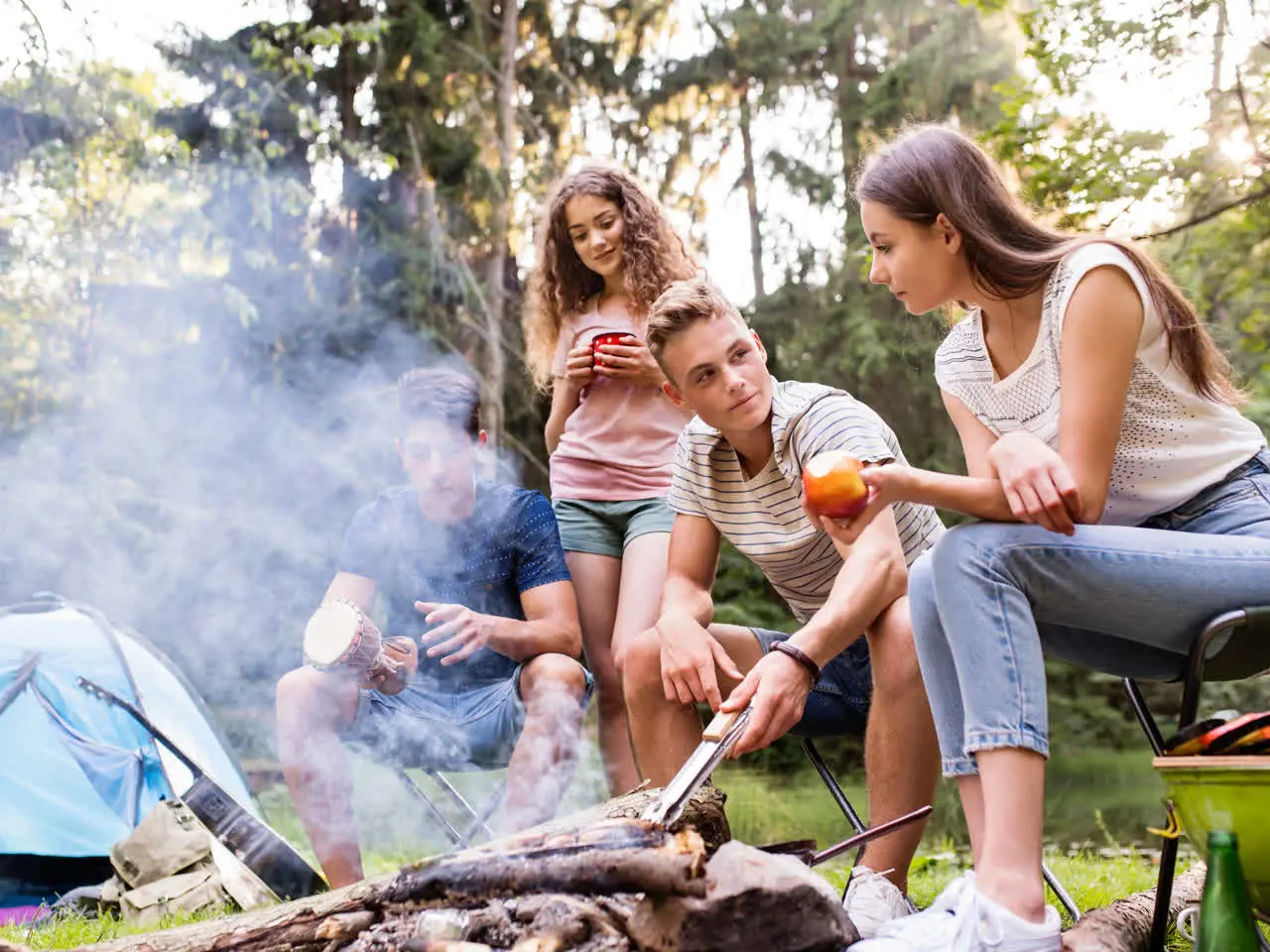 Family friends around a sunny campfire